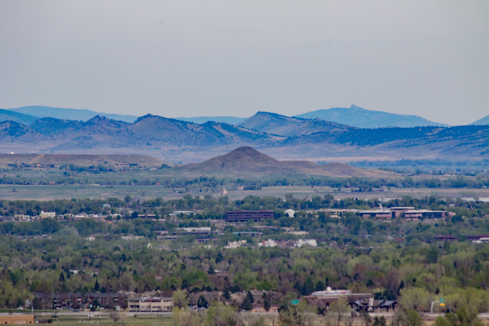 The valley floor below Niwot with a conical butte in the middle distance and the foothills of the Front Range behind it